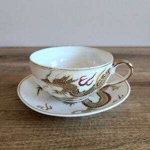 Dragonware Kutani porcelain cup and saucer with marriage dragon design.